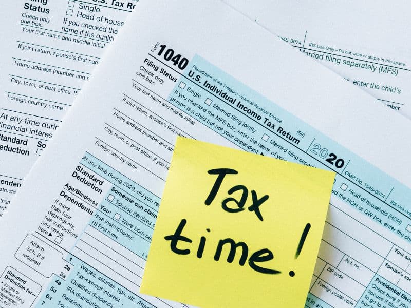 Total Tax time! a stack of paperwork with a sticky note on top that says "Tax time!"