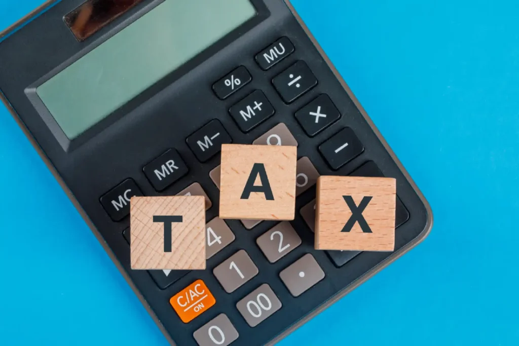 Small business back taxes with calculator and blocks that spell T A X